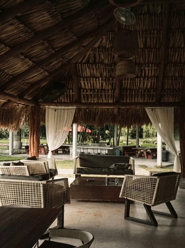 Interior de una palapa con muebles de mimbre