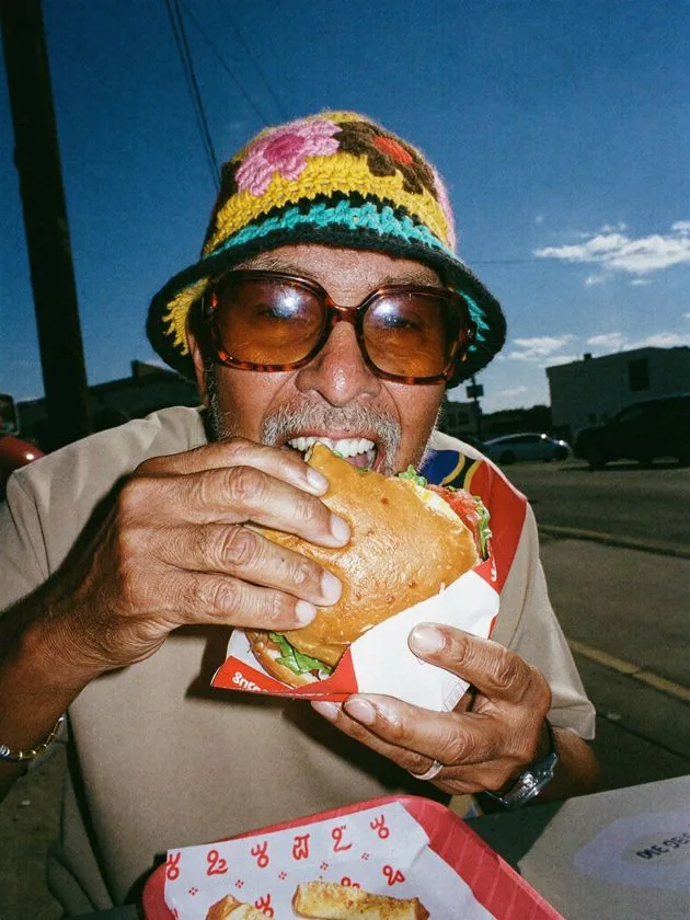 Cliente disfrutando una hamburguesa al aire libre